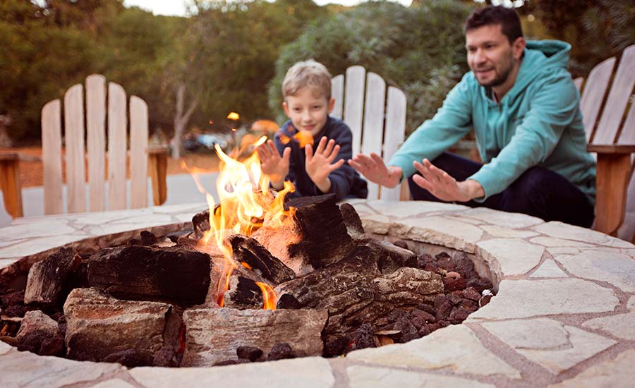 A father and a small boy next to an open fireplace​