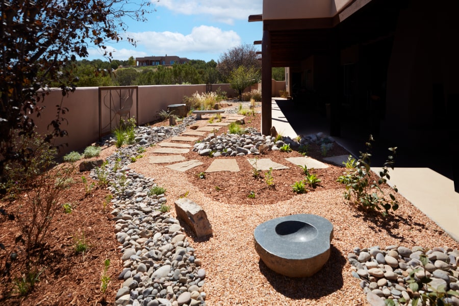 A landscaping design with drought-tolerant plants and stones​